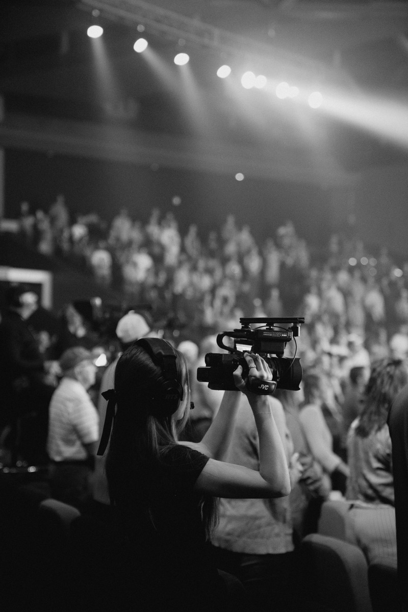 Bethany operating a video camera at a live event